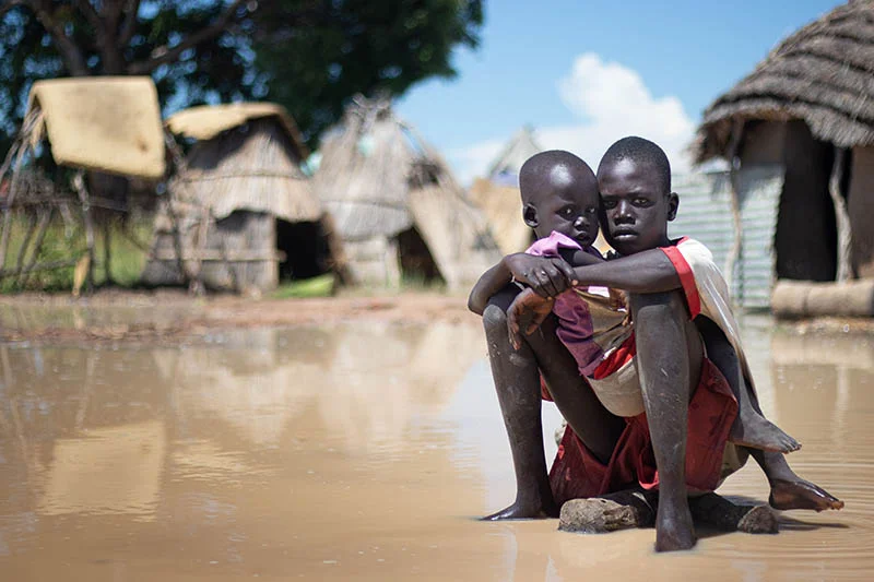 Children sit in flood water