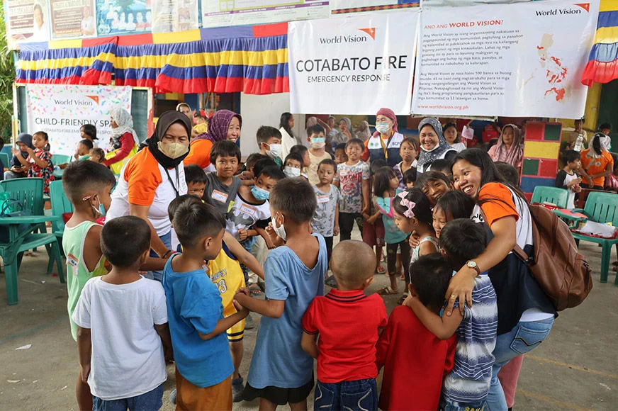 Children and World Vision staff are forming a circle during a Psychological First Aid activity through the Childhood Rescue Project. (Philippines, 2023)
