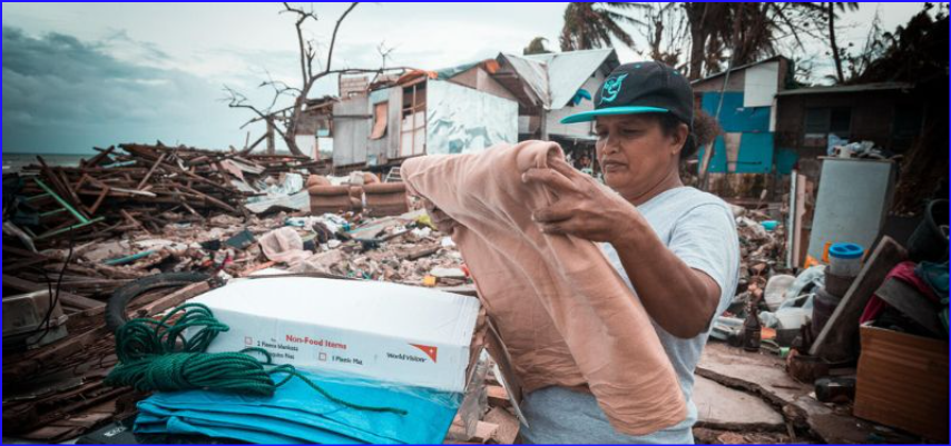  In the Philippines, a woman stands in the wreckage of her community after a typhoon