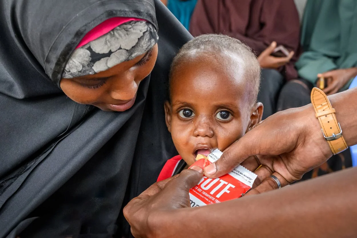 Child being fed an emergency food package.