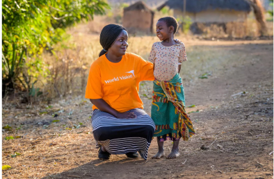 child with World Vision staff