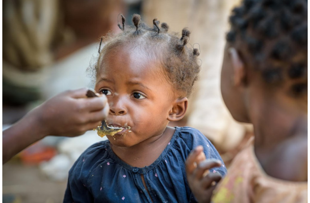 A child eating porridge from a spoon.